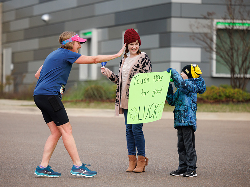 Jessica Overby and son Nathan thanked Run the Rainbow for Children's runners in front of the Kathy and Joe Sanderson Tower.